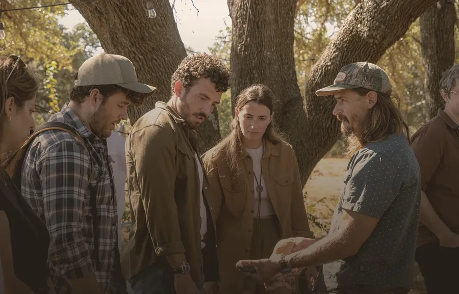 Visitors gather beneath oak trees for a ranch demonstration