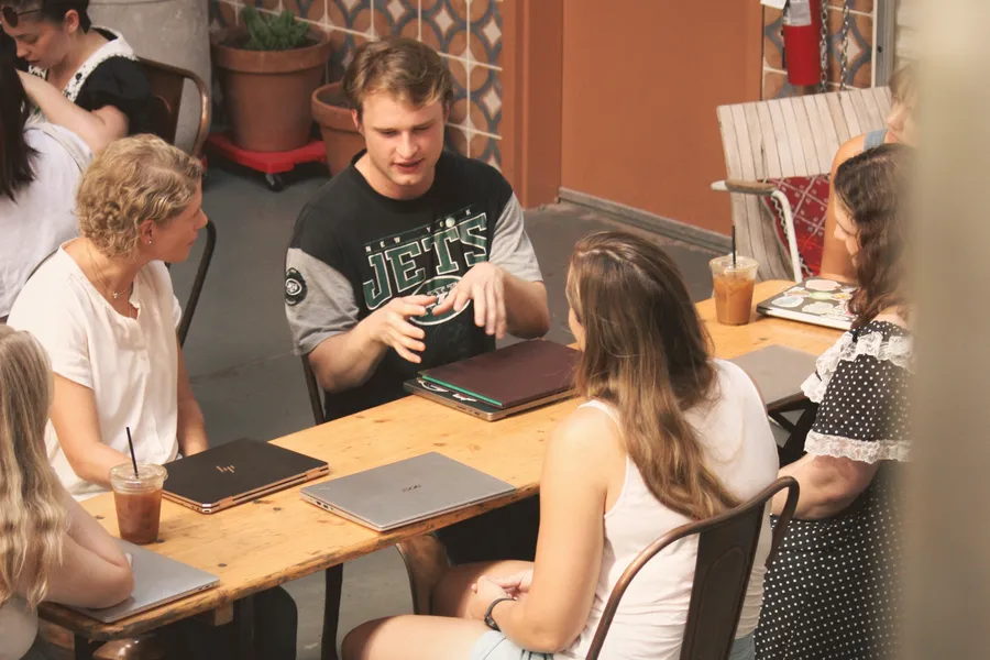 Five writers discussing a book around a table at an ATX Writing Club meeting