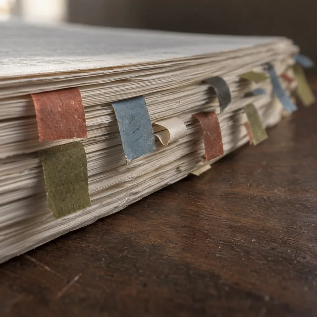 Archival paper, ink, and a ruler arranged for a careful draft