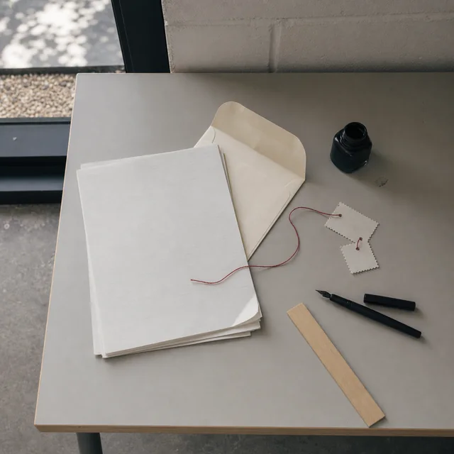 A finished submission packet tied with rust-colored thread